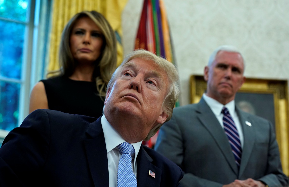 U.S. first lady Melania Trump, Vice President Mike Pence and U.S. President Donald Trump receive an update on Hurricane Harvey recovery efforts at the White House in Washington, U.S., September 1, 2017. (REUTERS/Kevin Lamarque)
