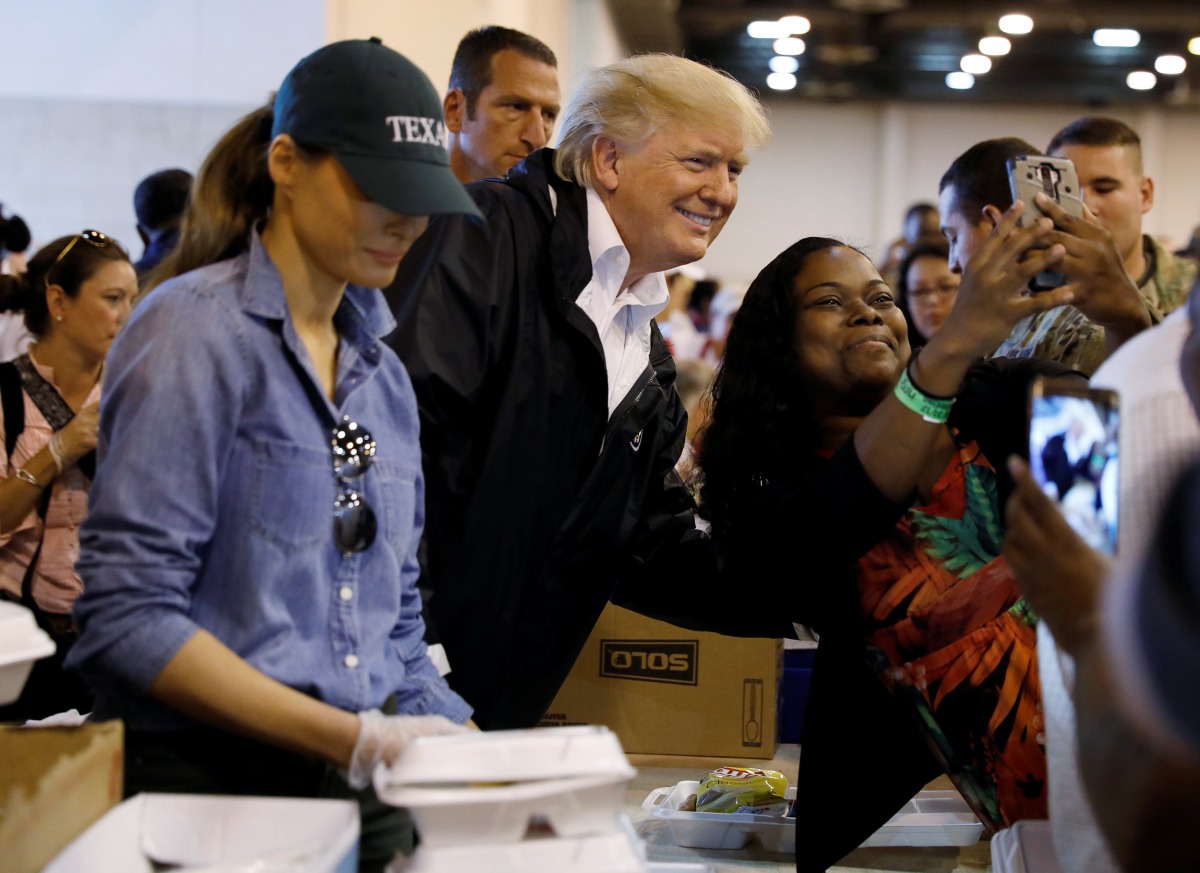 U.S. President Donald Trump poses for a photo as he and first lady Melania Trump help volunteers hand out meals during a visit with flood survivors of Hurricane Harvey at a relief center in Houston, Texas, U.S., September 2, 2017. REUTERS/Kevin Lamarque
