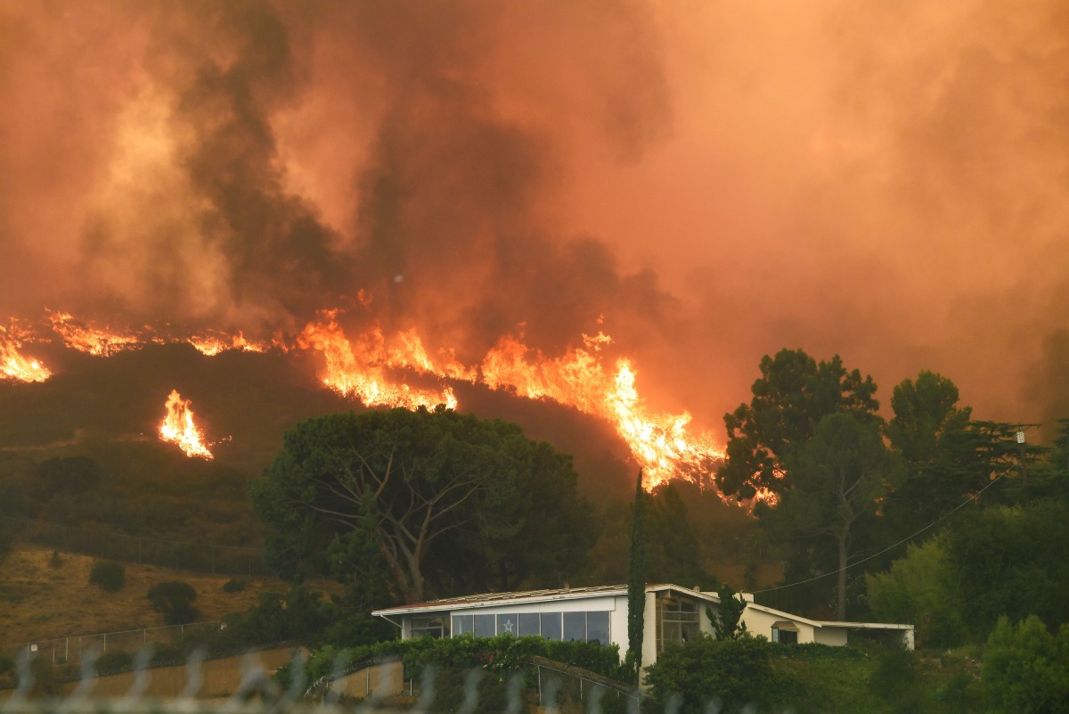 Flames from the La Tuna Fire blaze on a hill in the Shadow Hills neighborhood of Los Angeles, California, September 2, 2017. The La Tuna fire exploded to 8,000 acres on September 2, 2017, prompting mandatory evacuations and destorying three structures. It