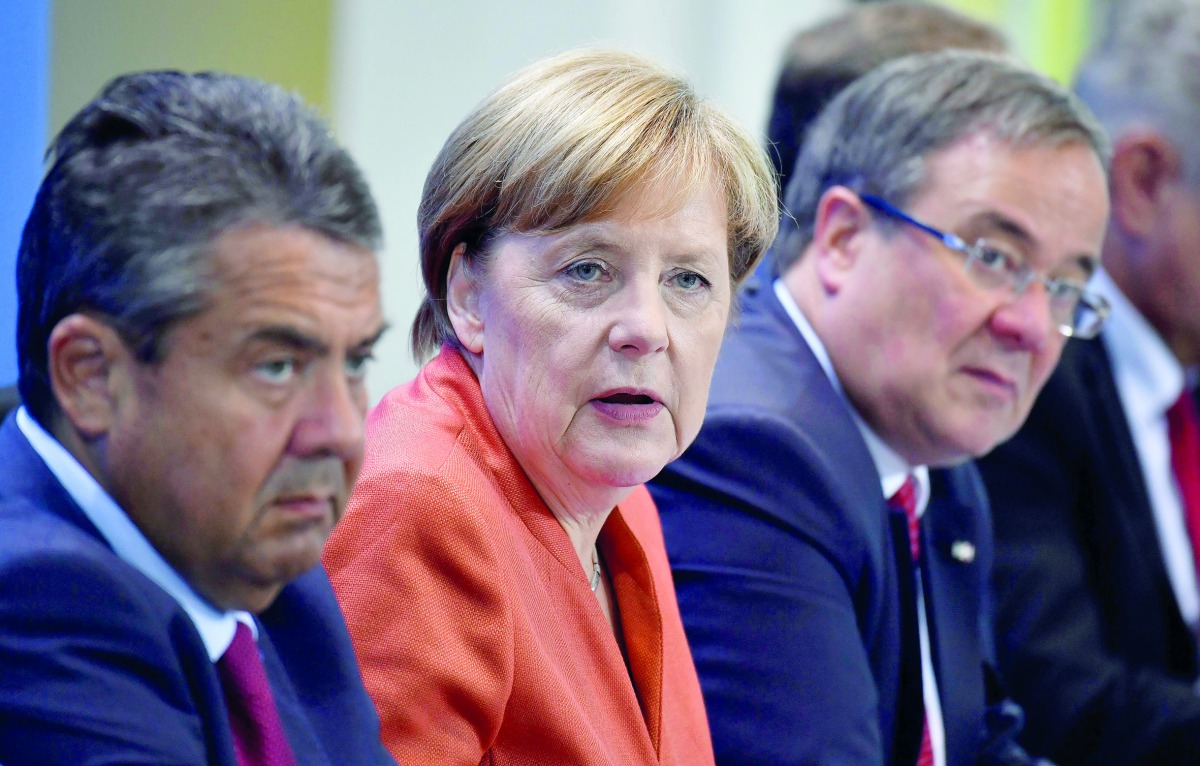 German Chancellor Angela Merkel (centre) with Sigmar Gabriel (left) German Vice Chancellor and Foreign Minister;  and Armin Laschet (right), North Rhine-Westphalia’s state premier as they address the media after a meeting on improving electric car infrast