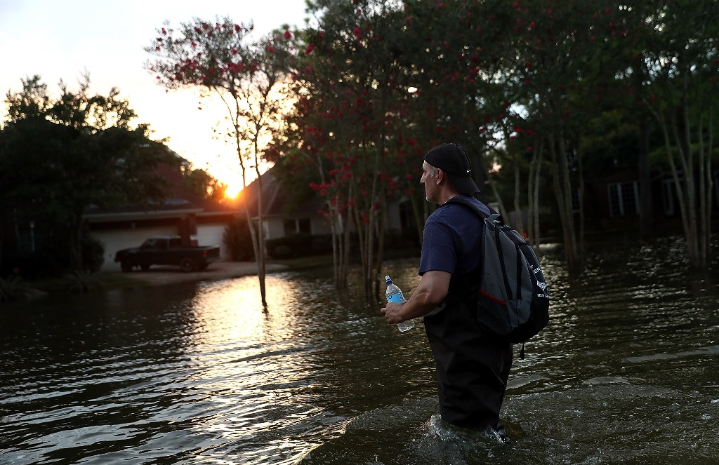 Samir Novruzov walks through a flooded street on September 4, 2017 in Katy, Texas. / AFP.