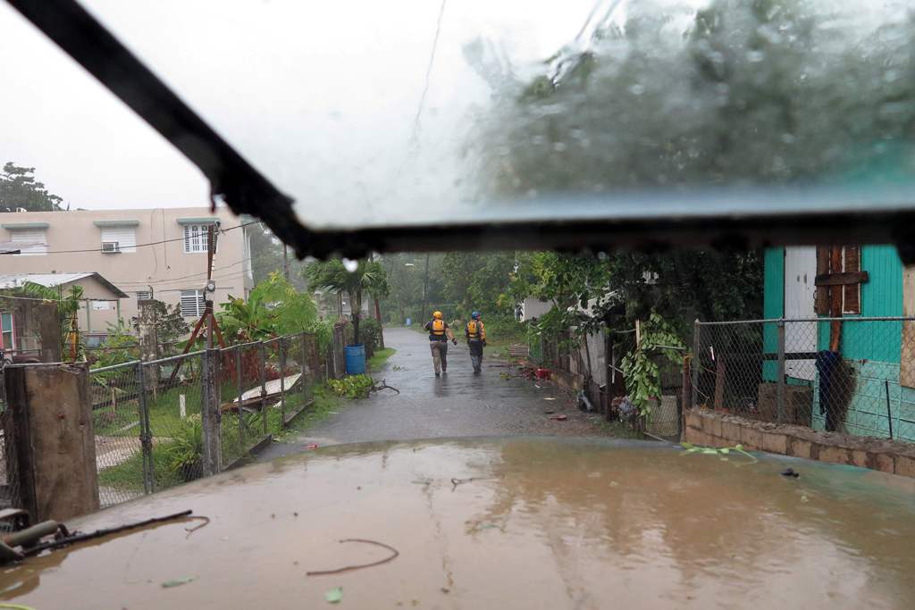 Search and rescue crew members walks a street during a search mission as hurricane Irma hits Puerto Rico in Fajardo on September 6,2017. / AFP.