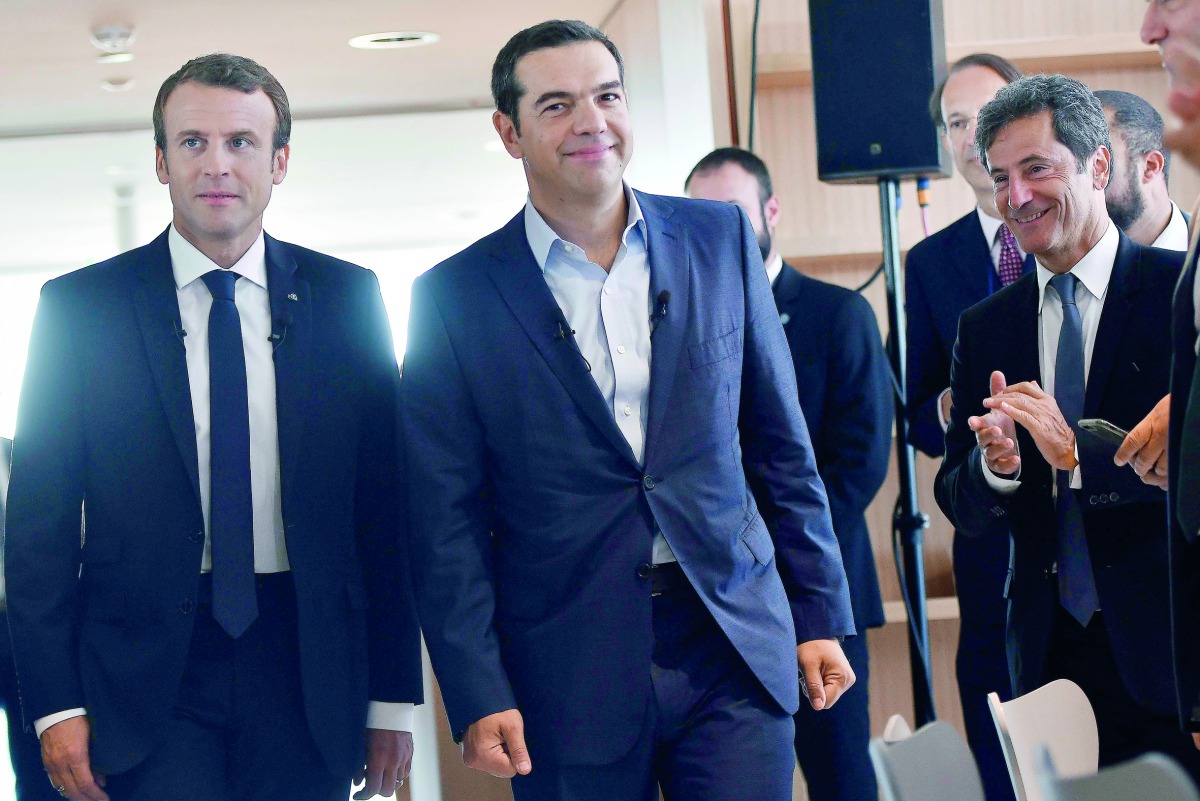 French President Emmanuel Macron (left) and Greek Prime Minister Alexis Tsipras (second left) arrive for a roundtable discussion with French and Greek business leaders yesterday in Athens, as part of a two-day official visit of the French president to Gre