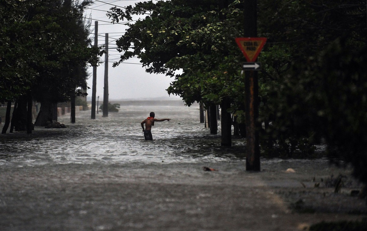 A man wades through a flooded street during the passage of Hurricane Irma, in Havana, on September 9, 2017. Irma's blast through the Cuban coastline weakened it to a Category Three, but it is still packing winds of 125 miles (200 kilometer) per hour. / AF