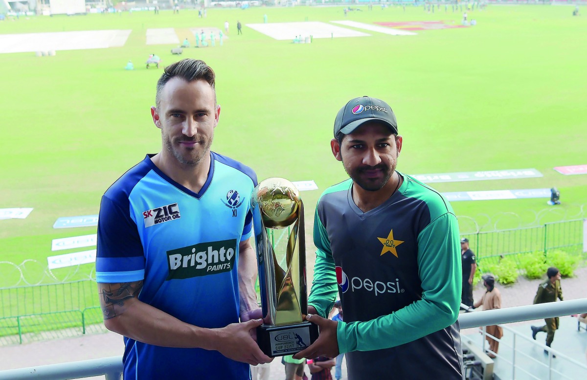 Pakistani cricket captain Sarfraz Ahmad (right) and International World XI captain Faf du Plessis hold the Independence Cup trophy during a press conference at the Gaddafi Cricket Stadium in Lahore, yesterday. 