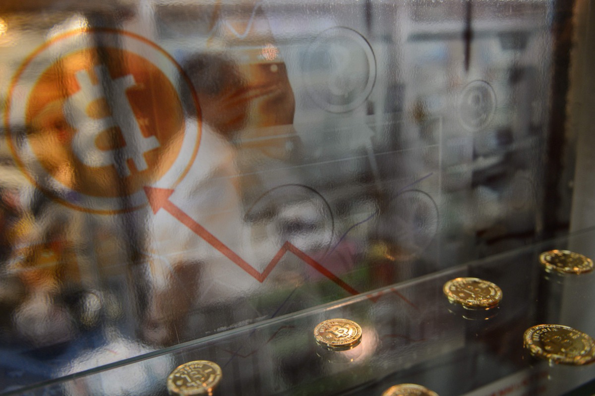 A man walking past a display cabinet containing models of Bitcoins in Hong Kong on August 3 2016 shows AFP Anthony Wallace