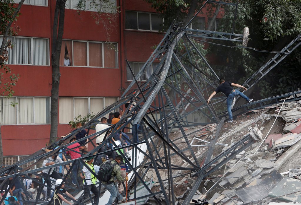 People climb over the debris of a collapsed building after an earthquake hit Mexico City, Mexico September 19, 2017. Picture taken September 19, 2017. REUTERS/Ginnette Riquelme.