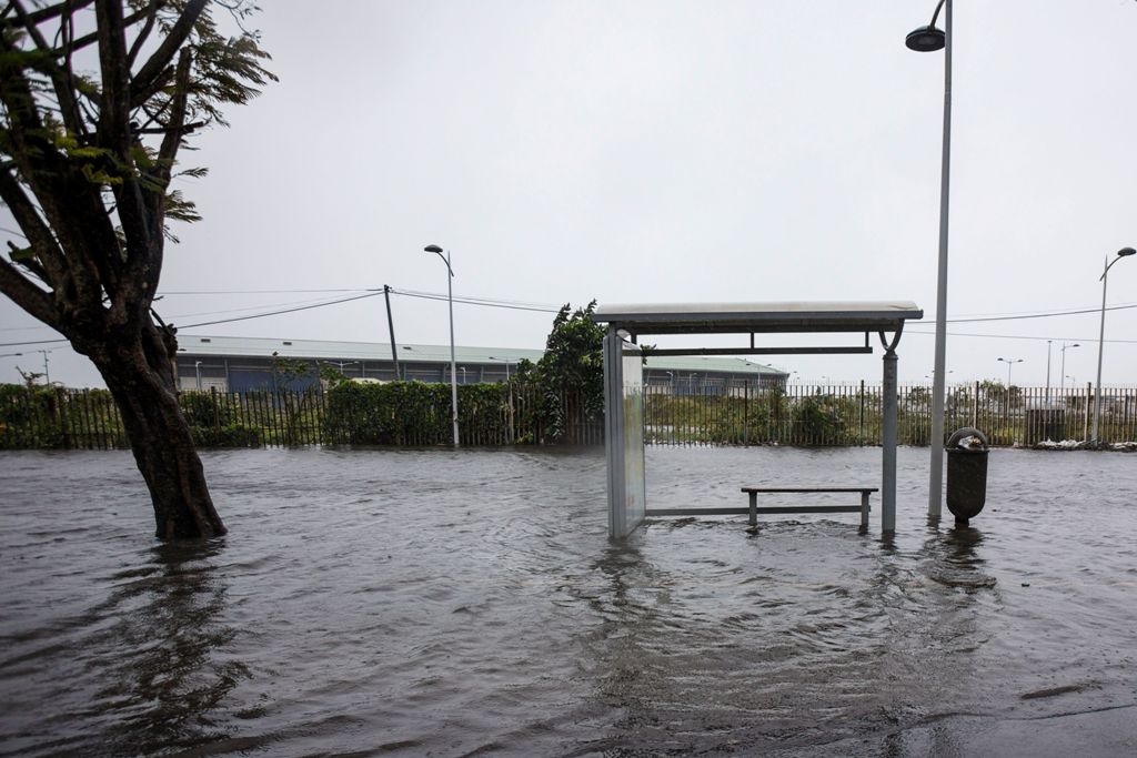 A flooded road and a bus stop are pictured on Boulevard Chanzy in downtown Pointe-a-Pitre on September 19, 2017 in the French territory of Guadeloupe after the passage of Hurricane Maria.  / AFP / Cedrick Isham CALVADOS