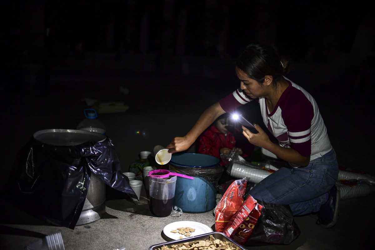 A woman prepares coffee in a square after a powerful quake hit Mexico City, late on September 19, 2017.  AFP / Ronaldo Schemidt