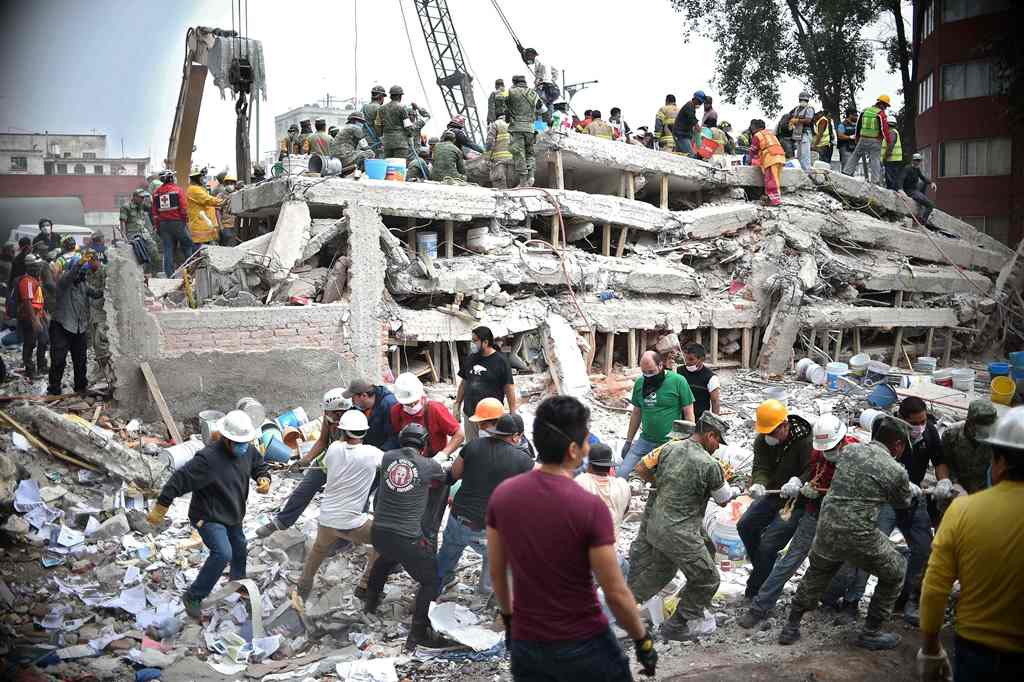 Rescuers, firefighters, policemen, soldiers and volunteers search for survivors in a flattened building in Mexico City on September 20, 2017 a day after a strong quake hit central Mexico. AFP / Yuri Cortez