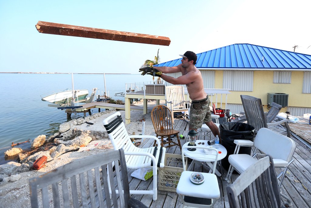 A man throws wood off the deck of a destroyed house following Hurricane Irma in Little Torch Key, Florida, U.S., September 20, 2017. REUTERS/Carlo Allegri
