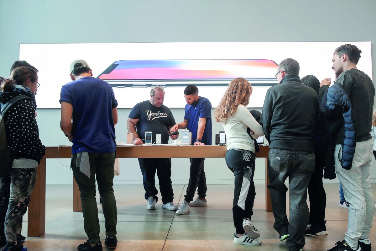 A customer purchases a new iPhone 8 at the Fifth Avenue Apple Store, September 22, 2017 in New York City. The new iPhone 8 and iPhone 8 Plus, as well as the updated Apple Watch and Apple TV, go on sale today. Drew Angerer/Getty Images/AFP