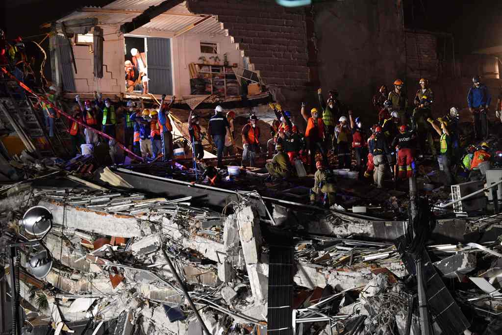 Rescue workers continue to search for survivors as night falls, in a collapsed building in Mexico City on September 22, 2017, three days after the powerful quake that hit central Mexico, causing panic among the megalopolis' 20 million inhabitants on the 3