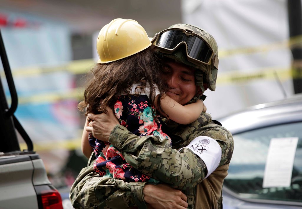 A girl hugs a Mexican marine officer as she offers hugs to people near the site of a collapsed building after an earthquake, in Mexico City, Mexico September 23, 2017. REUTERS/Jose Luis Gonzalez
