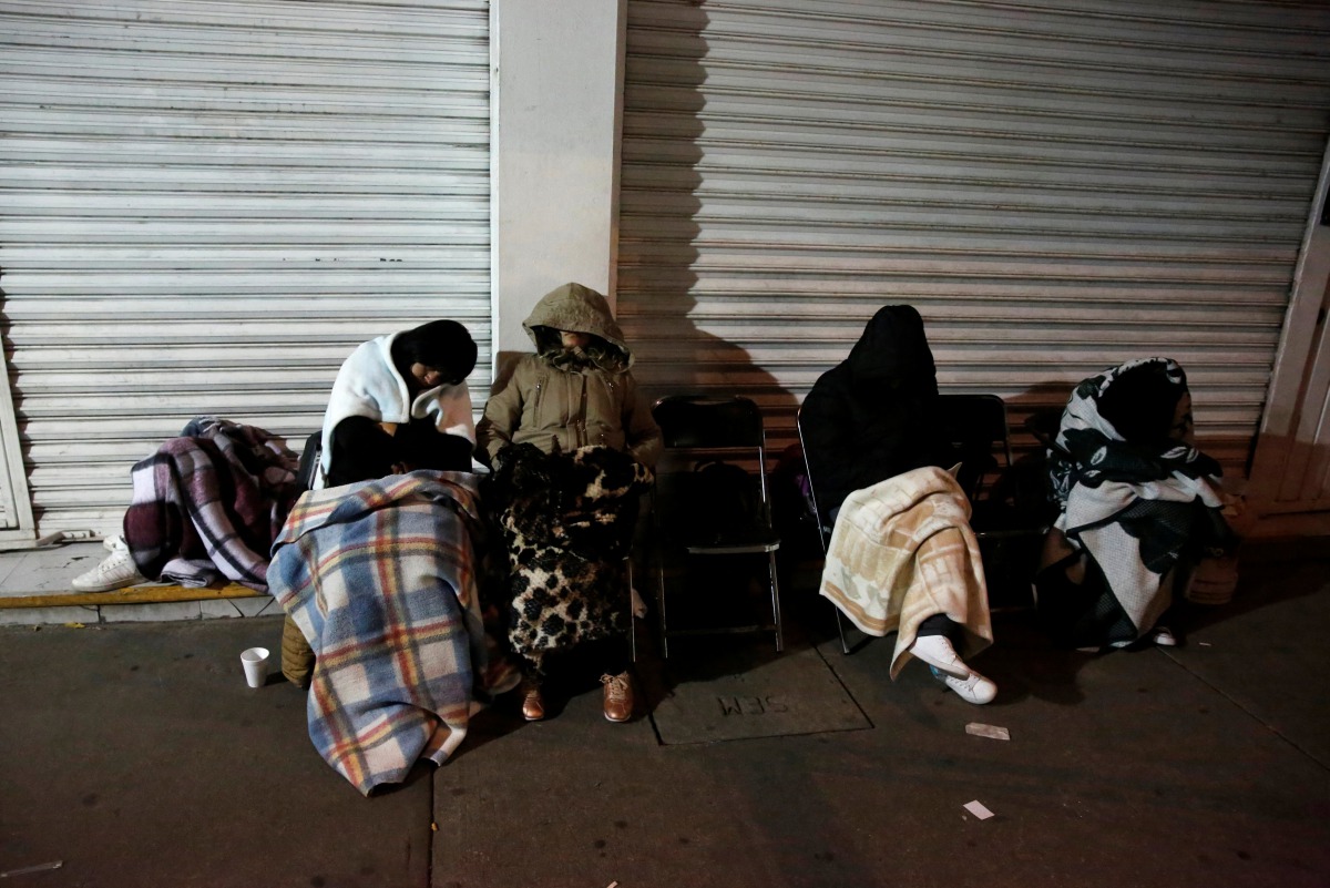 People sleep on the sidewalk next to a collapsed building after an earthquake as they wait for news of their loved ones in Mexico City, Mexico September 24, 2017. Reuters/Henry Romero