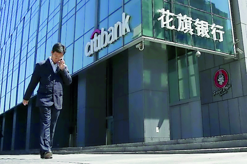A man walks past a branch of Citibank in Beijing.