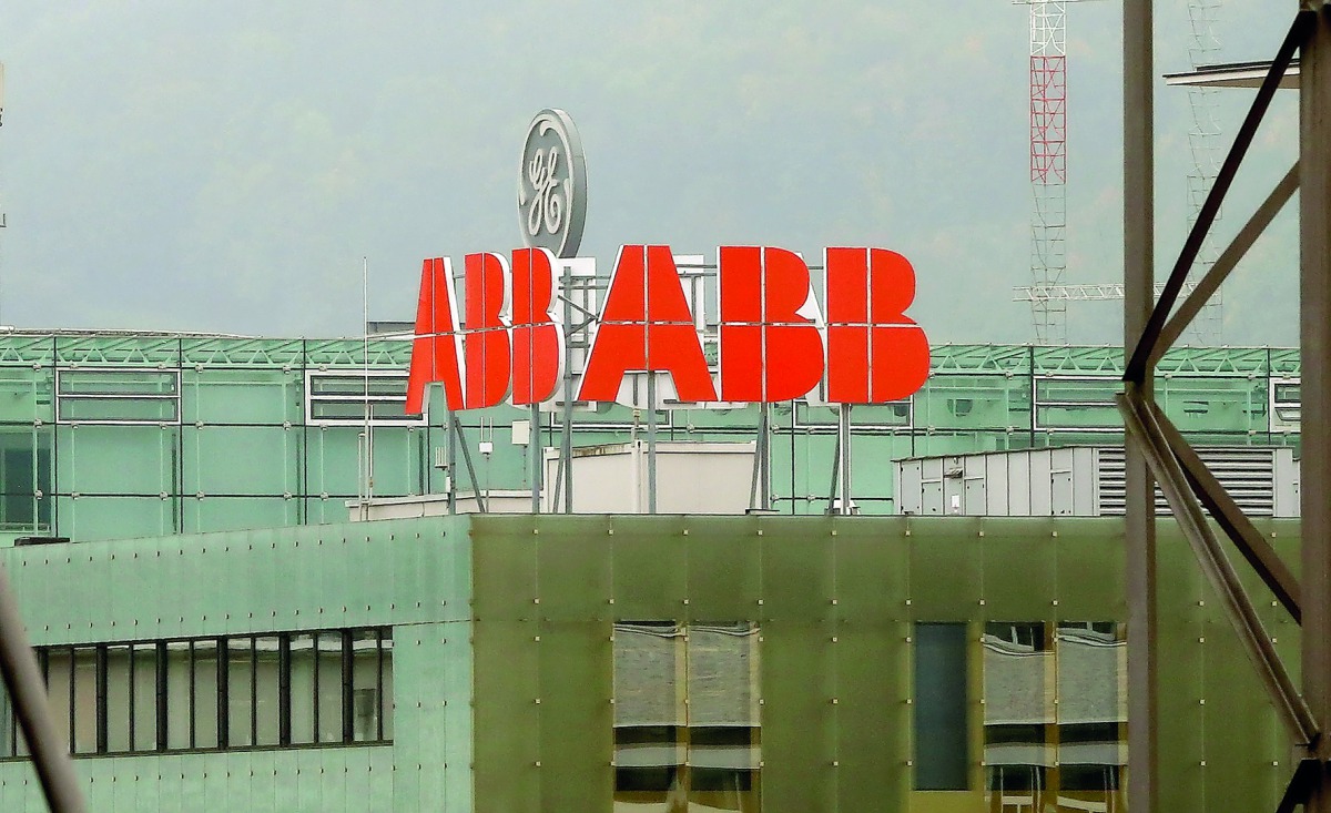 The logo of Swiss power technology and automation group ABB is seen in front of a logo of General Electric in Baden, Switzerland September 25, 2017. REUTERS/Arnd Wiegmann