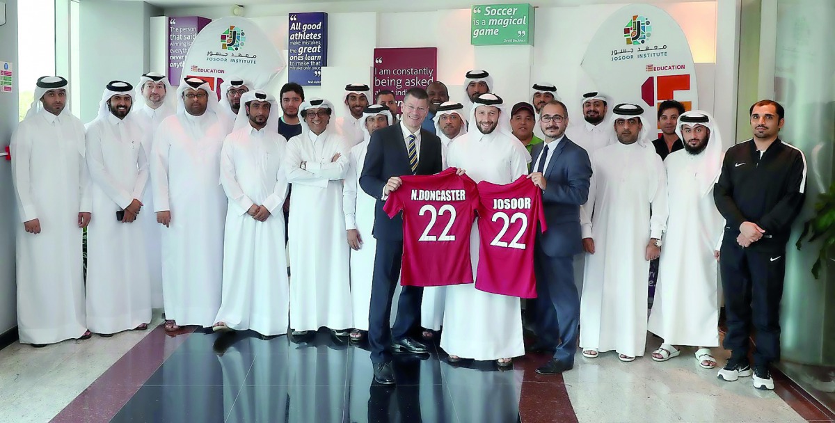 Neil Doncaster, Chief Executive of the Scottish Professional Football League and Director of Operations at the Qatar National Teams, Ahmed Khellil Abbassi along with QFA delegates pose for a group photo following the conclusion of workshop at Aspire Acade