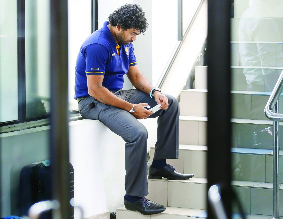 Sri Lanka’s Lasith Malinga looks at his mobile phone while waiting at Sri Lanka Cricket headquarters in Colombo in this file photo.