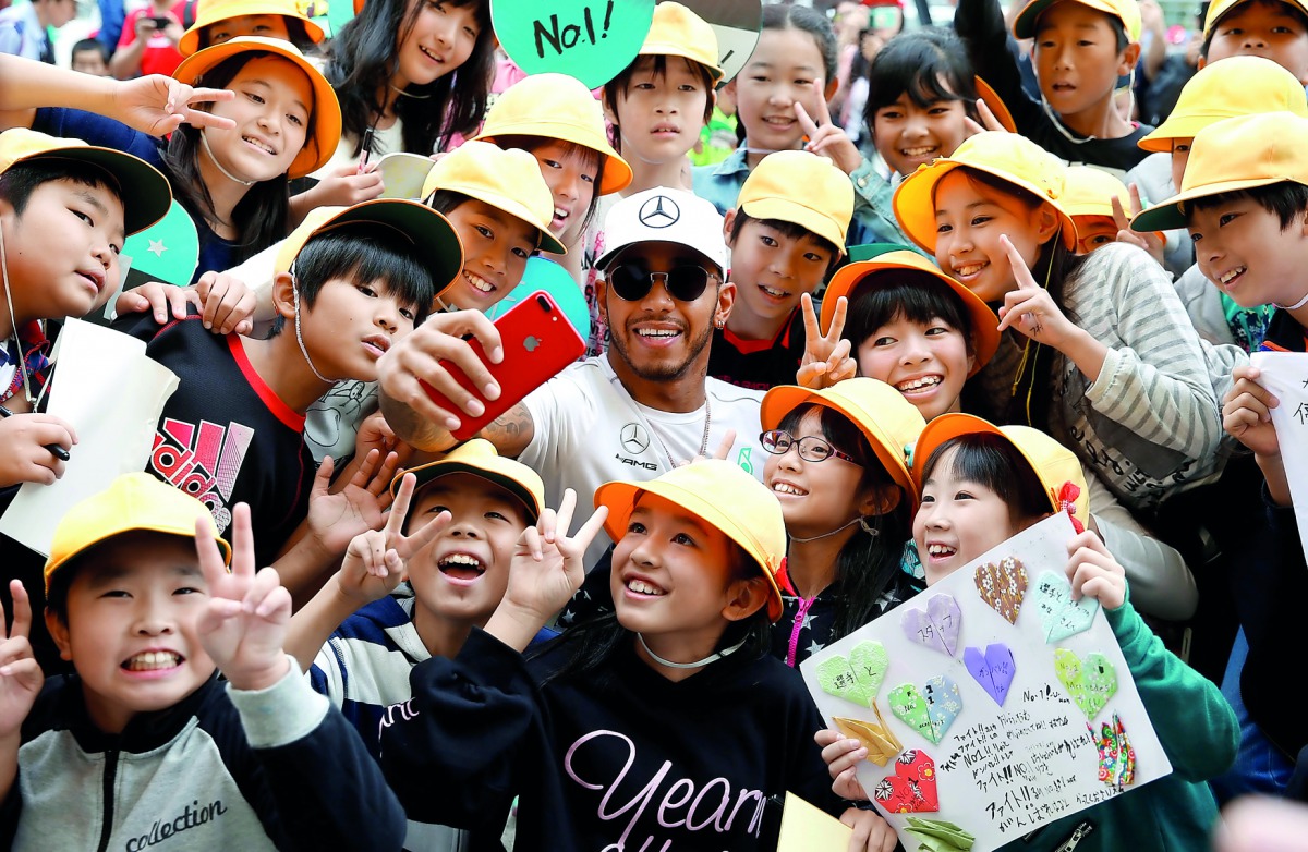 Mercedes’ Lewis Hamilton takes a selfie with local students at the Suzuka Circuit in Suzuka, Japan ahead of the Formula One Japanese Grand Prix yesterday.