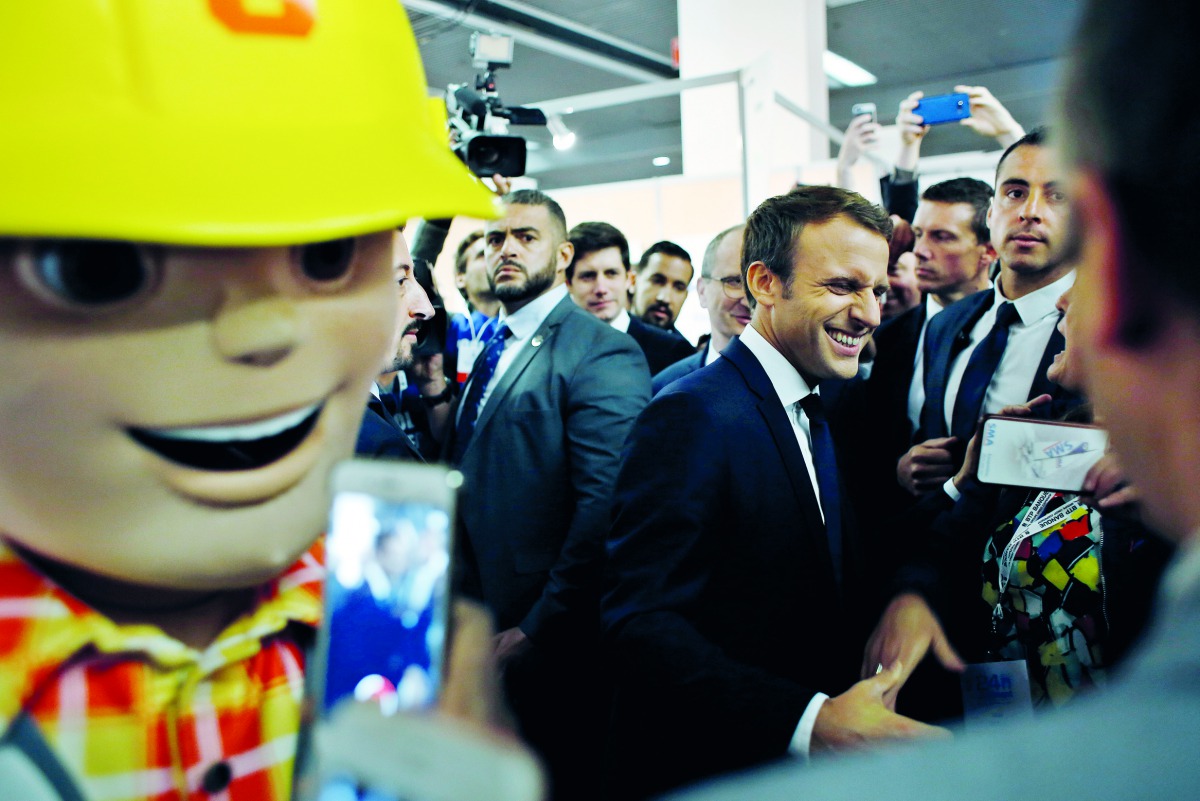 France's President Emmanuel Macron (C) smiles as he visits the construction fair in Paris, on October 6, 2017.  AFP/ Thibault Camus