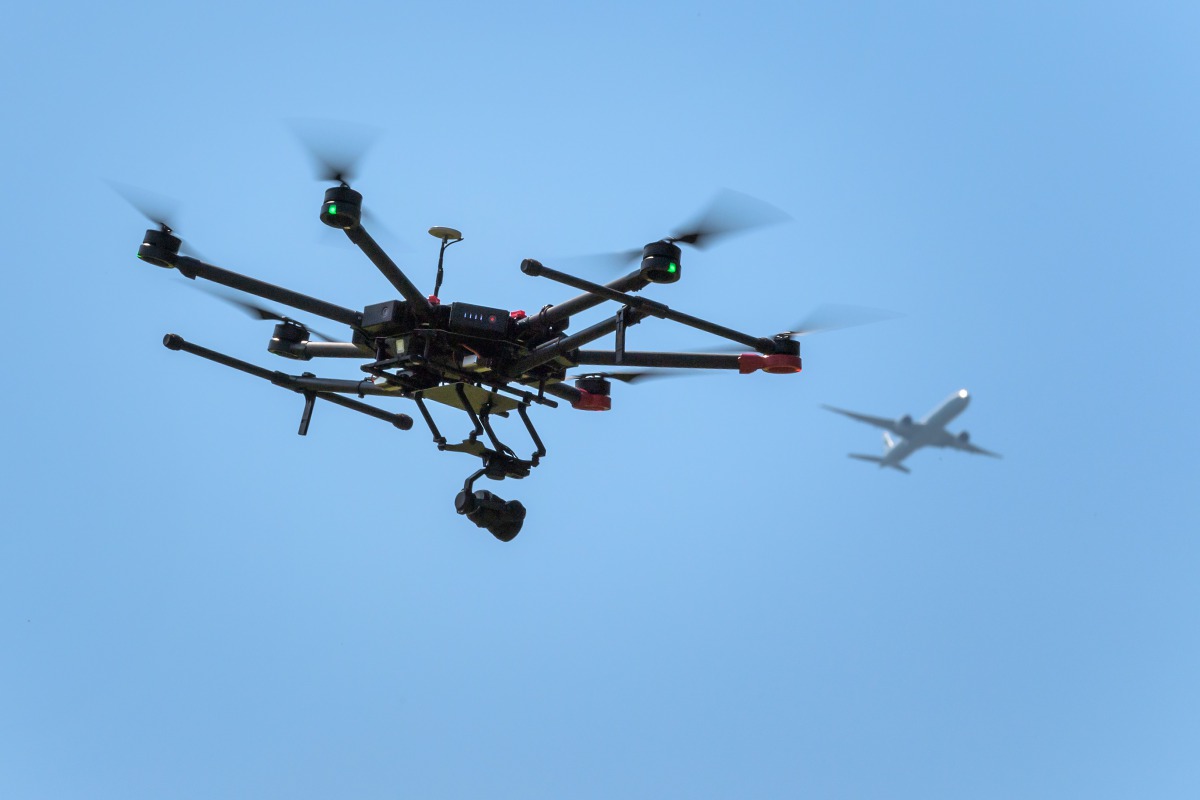 FILE PHOTO: A drone flies as an airplane is seen in the background during a press presentation of Swiss disaster dog association Redog on combined search and rescue outside Zurich on August 23, 2017 (AFP / Fabrice Coffrini) 