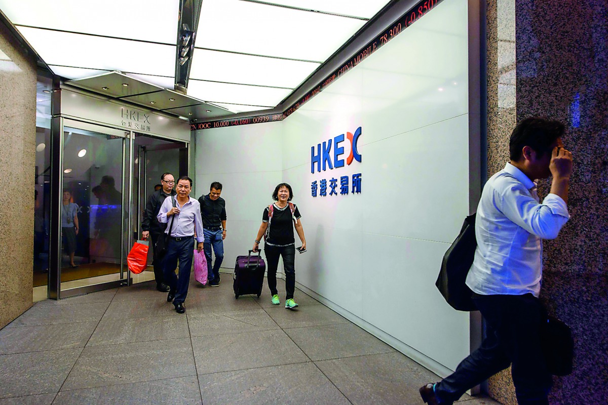 In this picture taken on October 19, 2017, Cheng (C), a trader who worked on the floor since 1994, leaves the Hong Kong Stock Exchange after finishing her last day of work as a floor trader. AFP / Anthony Wallace 