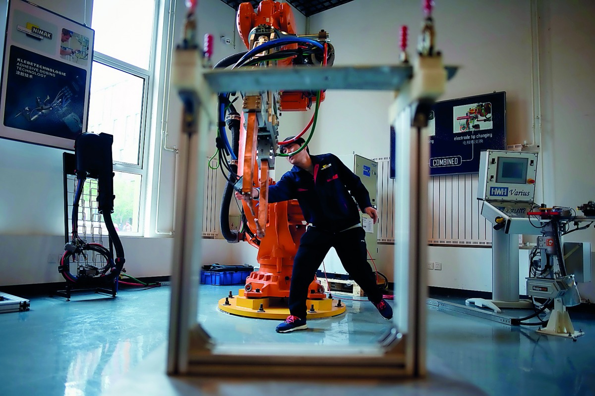 A worker checks a robot arm at a robot company during a tour arranged by the press center for the 19th Communist Party Congress in Xianghe county in China's Hebei province on October 22, 2017. AFP / Wang Zhao