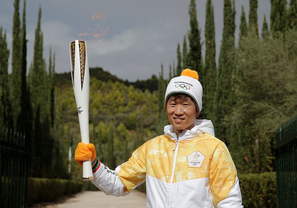 Former South Korea footballer Park Ji-sung poses with the Olympic torch with the flame during the Olympic flame lighting ceremony for the Pyeongchang 2018 Winter Olympics. REUTERS/Alkis Konstantinidis
