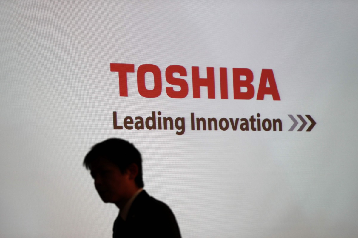 A man walking past the logo of Toshiba Corp displayed at the company headquarters in Tokyo on February 14, 2017 (AFP / Behrouz Mehri) 