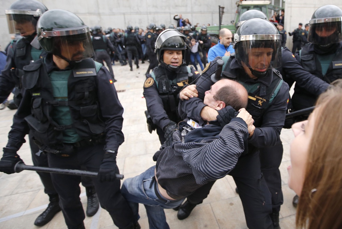 Spanish Guardia Civil guards drag a man outside a polling station in Sant Julia de Ramison, October 1, 2017 on the day of a referendum on independence for Catalonia banned by Madrid (AFP / Raymond Roig) 