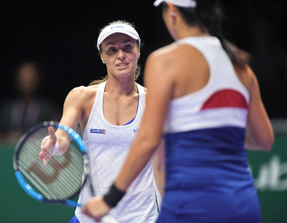 Switzerland's Martina Hingis (L) gestures towards Taiwan's Chan Yung-Jan (R) during their women's doubles semi-final match against Timea Babos and Andrea Hlavackova at the WTA Finals tennis tournament in Singapore on October 28, 2017. (AFP)