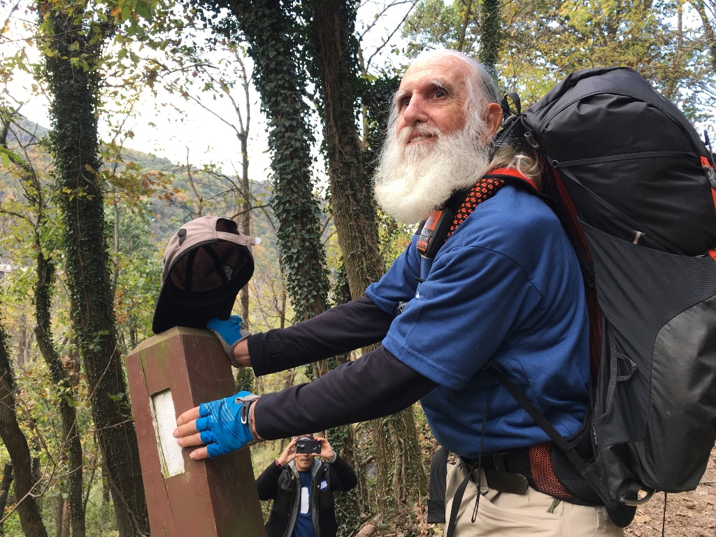 Dale Sanders, 82, stopped to kiss his last trail marker before becoming the oldest person to hike all 2,190 miles of the Appalachian Trail within a year. Washington Post photo by Tara Bahrampour
