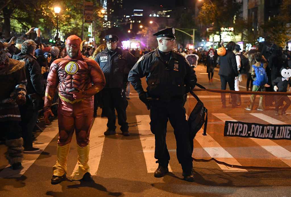 NYPD officers stand guard during the 44th Annual Halloween Parade in New York on October 31, 2017. / AFP / ANGELA WEISS