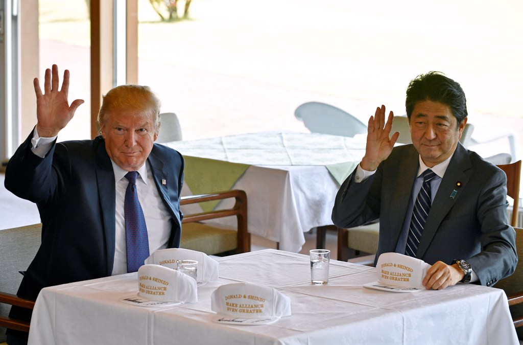 US President Donald Trump (L) and Japanese Prime Minister Shinzo Abe (R) wave to reporters after they signed hats reading 'Donald and Shinzo, Make Alliance Even Greater' at the Kasumigaseki Country Club in Kawagoe, Japan on November 05, 2017. Anadolu Agen