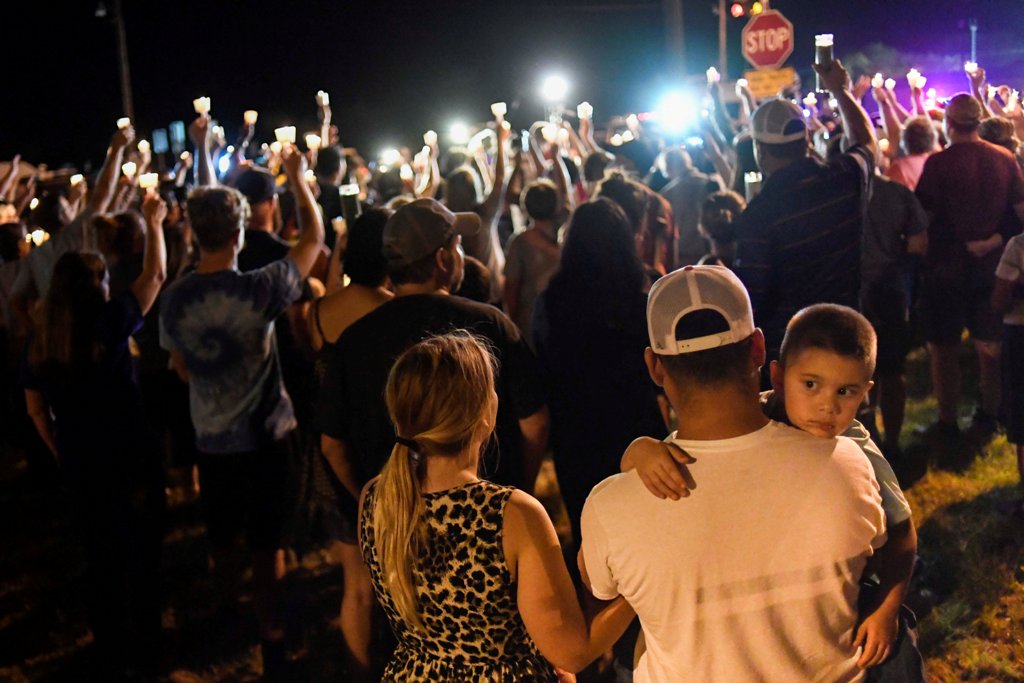 Local residents embrace during a candlelight vigil for victims of a mass shooting in a church in Sutherland Springs, Texas, U.S., November 5, 2017. REUTERS/Mohammad Khursheed.