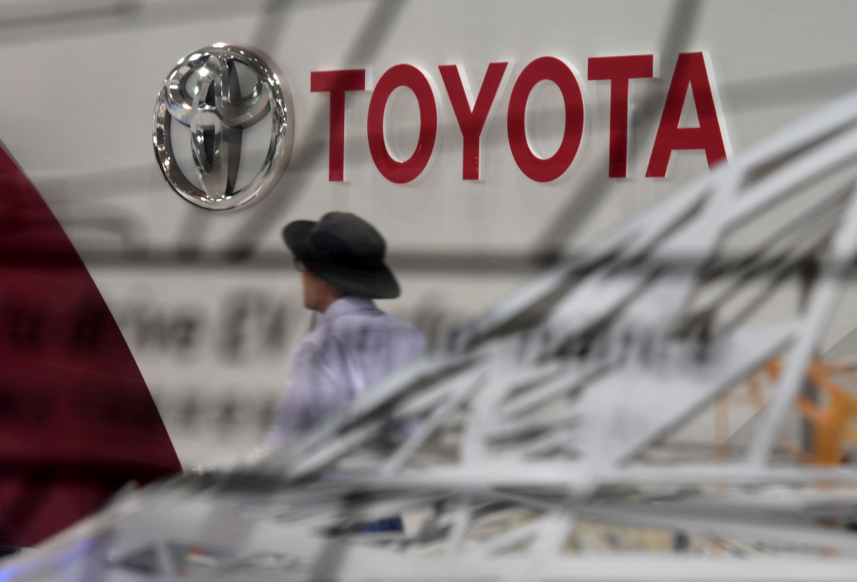 This file photo taken on September 19, 2017 shows visitors walking at the Mega Web Toyota showroom in Tokyo. Japanese car giant Toyota on November 7, 2017 revised its full-year net profit forecast higher thanks to a cheaper yen and cost-cutting efforts. A