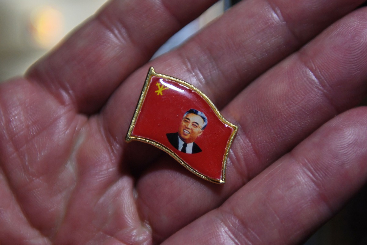 A Chinese vendor displays a pin with an image of North Korean founder Kim Il Sung in the border city of Dandong in China's northeast Liaoning province on September 3, 2017 (AFP / Greg Baker) 
