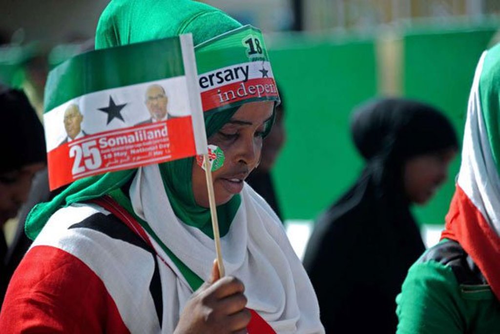 This file photo taken on May 18, 2016 shows a woman holding a flag as soldiers and other military personnel of Somaliland march past during an Independence day celebration parade in the capital, Hargeisa. The country will hold elections on Monday. PHOTO |