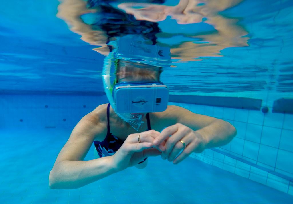 A therapist tests out new cutting-edge waterproof virtual reality glasses playing a film of dolphins, at the 'S Heeren Loo care centre for disabled people in Apeldoorn, on October 31, 2017, eastern Netherlands. AFP / JOHN THYS