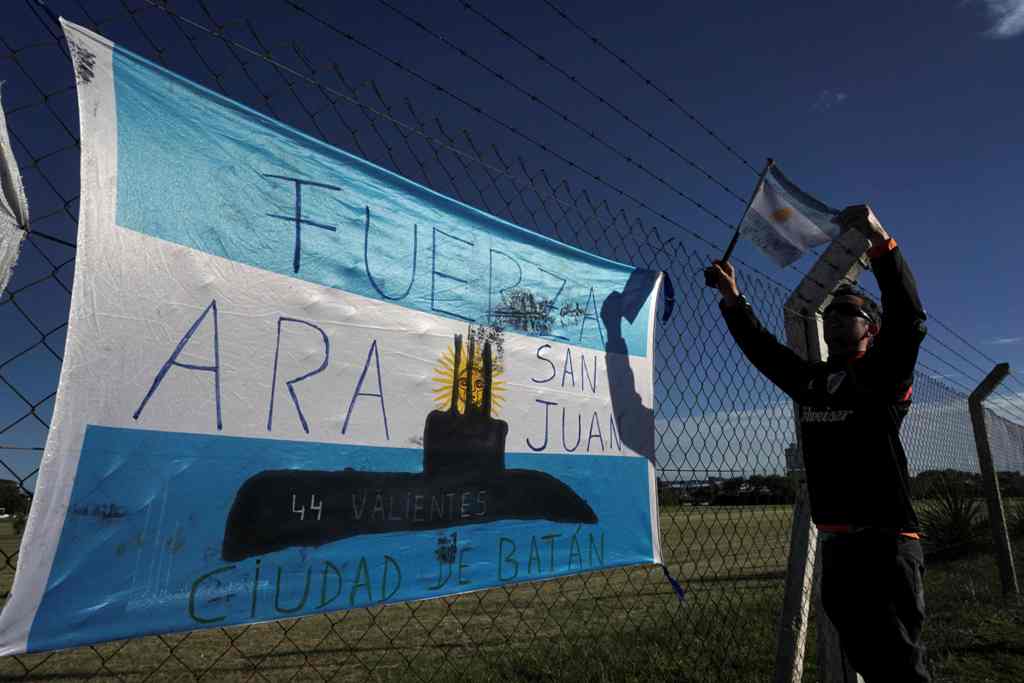 A man hangs an Argentinian flag outside Argentina's Navy base in Mar del Plata, on the Atlantic coast south of Buenos Aires, on November 22, 2017. AFP / EITAN ABRAMOVICH
