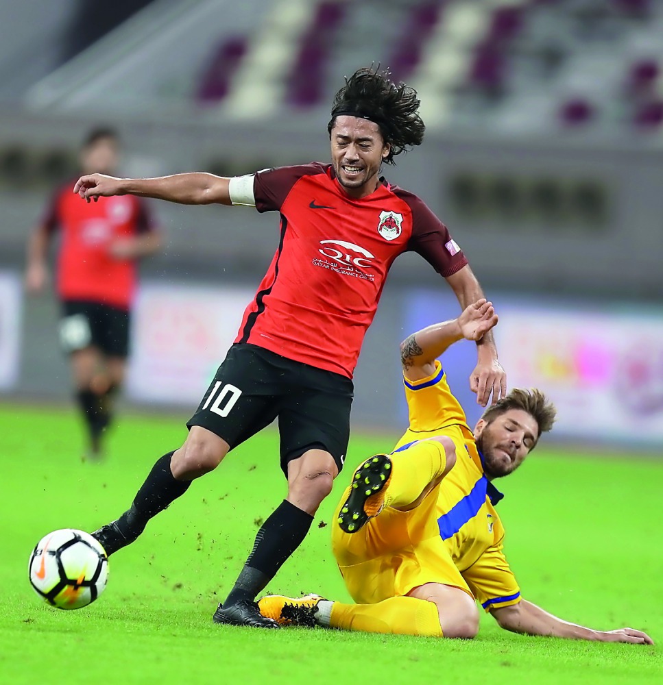 Al Rayyan’s  Rodrigo Tabata (left) vies for ball possession with an Al Gharafa player during the QNB Stars League at Khalifa International Stadium yesterday. 
