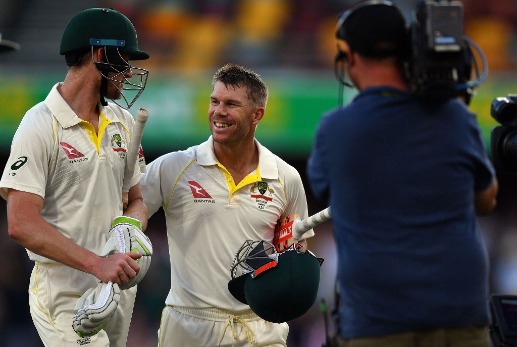 Australia's unbeaten batting pair David Warner (C) and Cameron Bancroft (L) walk back to the pavilion at the end of fourth day's play of the first cricket Ashes Test between England and Australia in Brisbane on November 26, 2017. AFP / Saeed Khan 