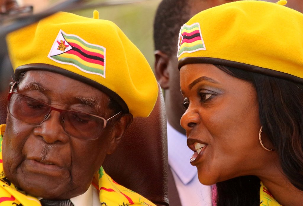 President Robert Mugabe listens to his wife Grace Mugabe at a rally of his ruling ZANU-PF party in Harare, Zimbabwe, November 8, 2017. Picture taken November 8, 2017. REUTERS/Philimon Bulawayo