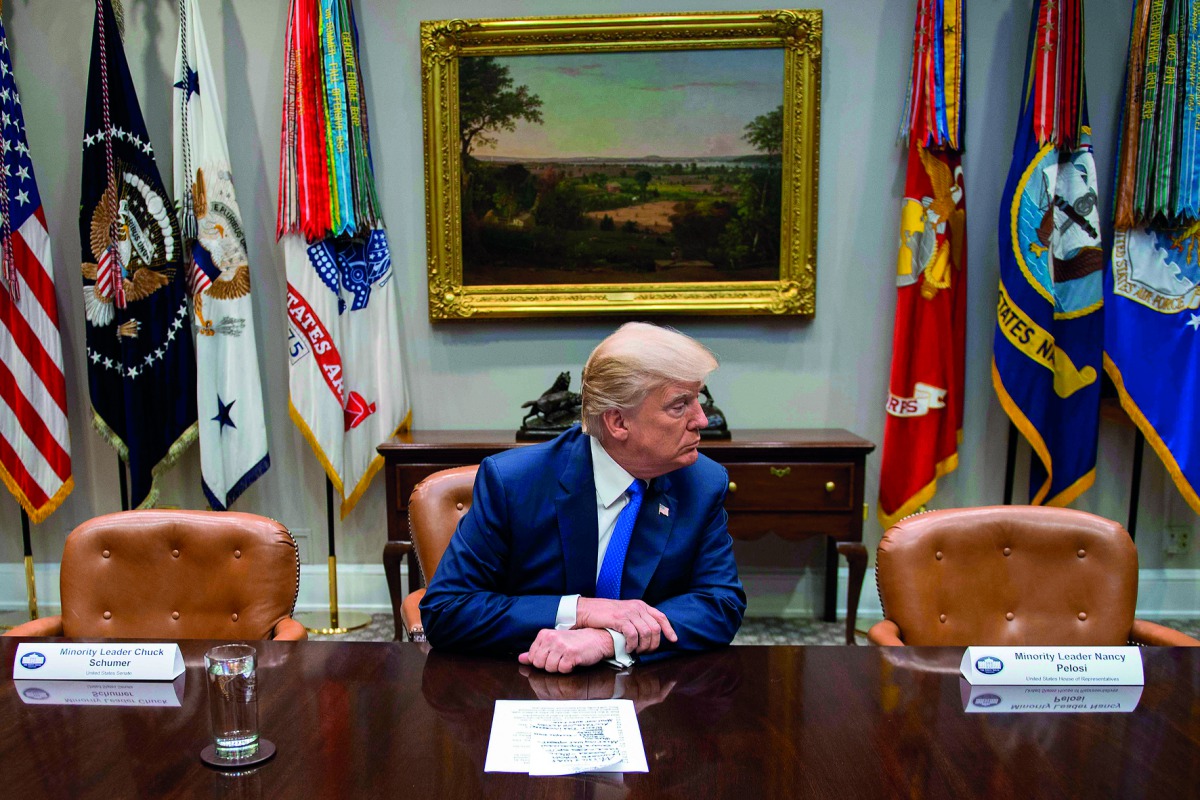 US President Donald Trump (C) makes a statement from the Roosevelt Room next to the empty chairs of Senate Minority Leader Chuck Schumer (L), D-New York, and House Minority Leader Nancy Pelosi (R), D-California, after they cancelled their meeting at the W