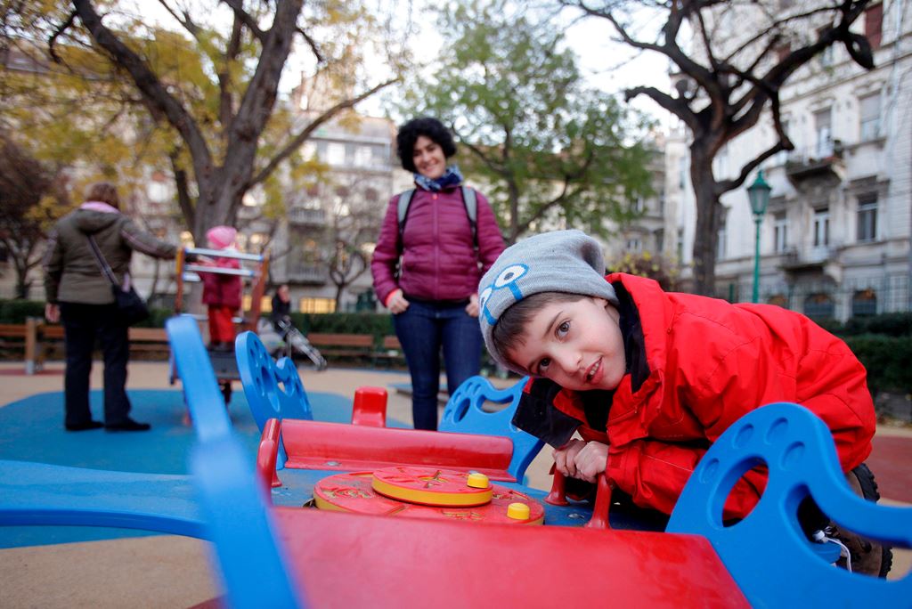 Aron (R) looks into the camera, at a local playground in Budapest on November 22, 2017. AFP / Peter Kohalmi  