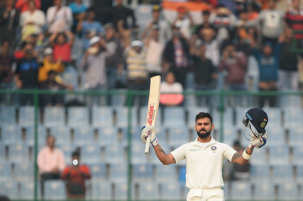 Indian batsman and team captain Virat Kohli raises his bat after scoring a century (100 runs) during the first day of the third Test cricket match between India and Sri Lanka at the Feroz Shah Kotla Cricket Stadium in New Delhi on December 2, 2017. AFP / 