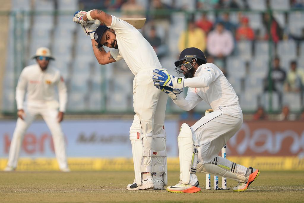 Indian batsman and team cptain Virat Kohli watches the ball after he plays a shot during the first day of the third Test cricket match between India and Sri Lanka at the Feroz Shah Kotla Cricket Stadium in New Delhi on December 2, 2017. (AFP / SAJJAD HUSS