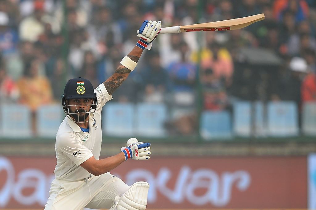 Indian batsman and team captain Virat Kohli (R) plays a shot during the second day of the third Test cricket match between India and Sri Lanka at the Feroz Shah Kotla Cricket Stadium in New Delhi on December 3, 2017. GETTYOUT / AFP / SAJJAD HUSSAIN 