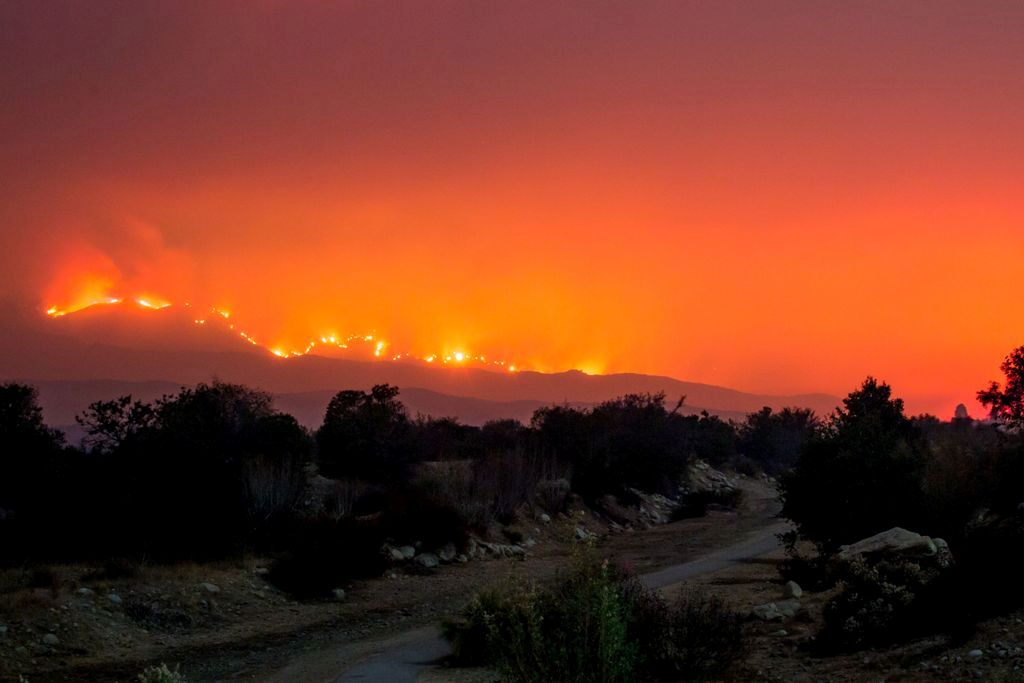 The Thomas Fire burns behind trails on Old Baldwin Road in Ojai, California on December 6, 2017. / AFP.